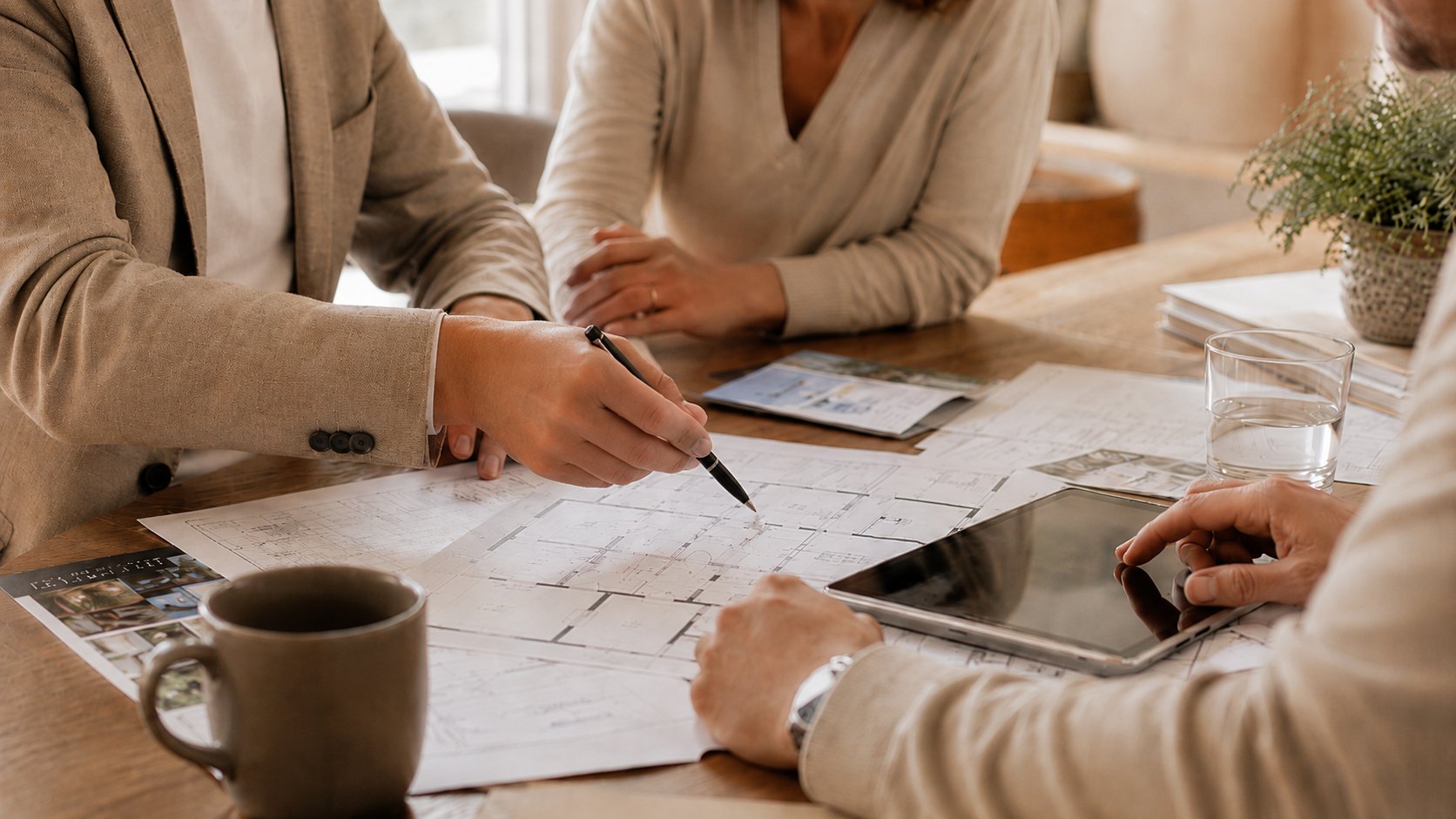 Gros plan sur un plan de maison et une tablette lors d'un rendez-vous diagnostic